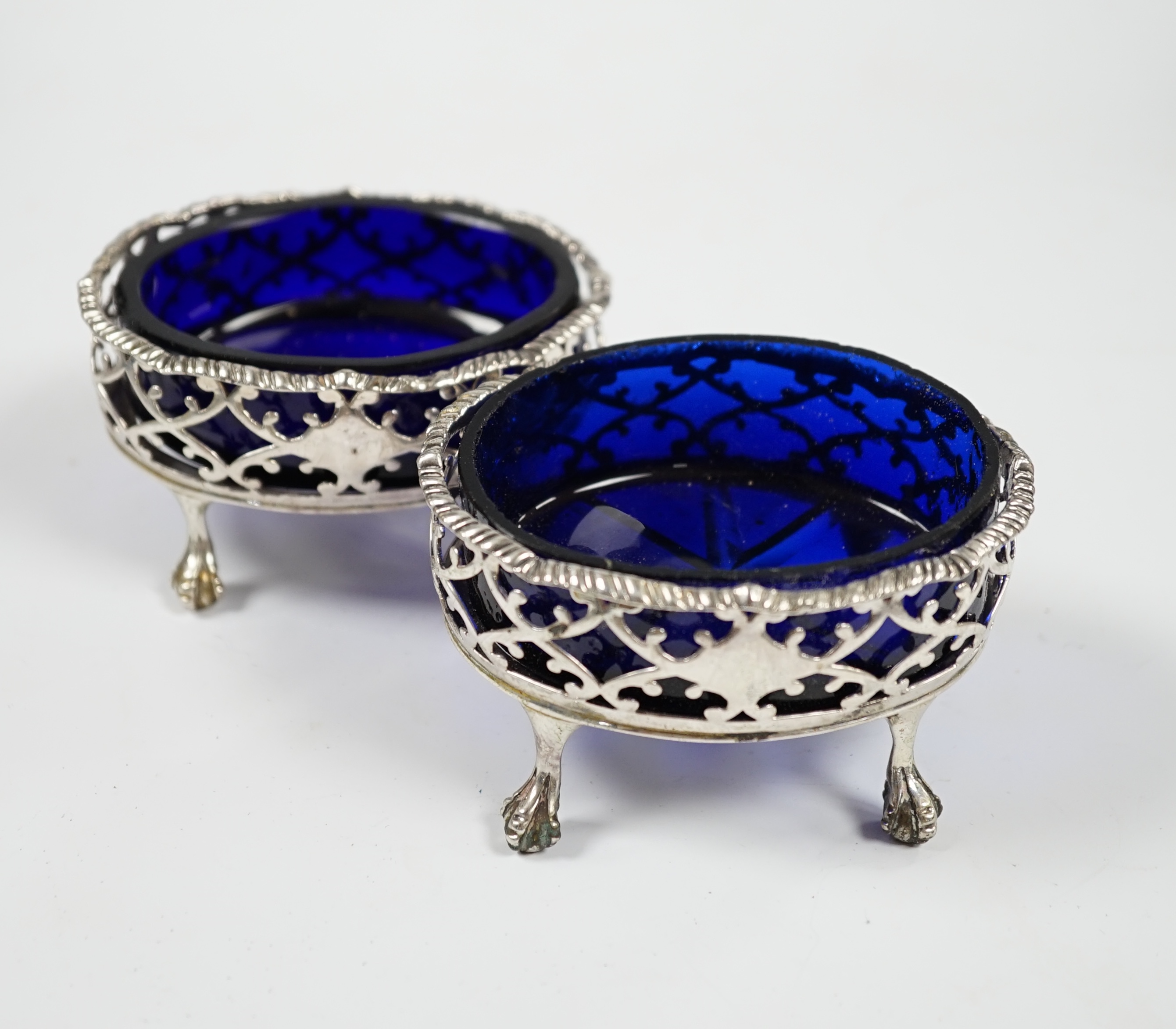 A pair of late George II pierced silver oval salts, by Robert & David Hennell I, London, 1759, with associated blue glass liners, 83mm. Condition - poor